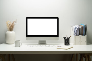 blank empty desktop computer, potted plant and books on white table. white screen for your advertisi