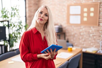 Sticker - Caucasian woman working at the office with tablet relaxed with serious expression on face. simple and natural looking at the camera.