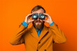  a man carefully look through binoculars on a orange background.generative AI.