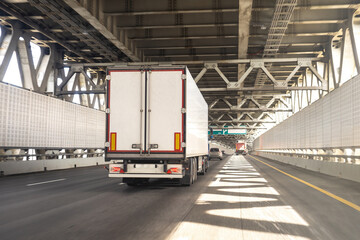 Wall Mural - Truck is driving down road. Automobile cargo transportation. Truck with white body back view. Lorry in tunnel. Transportation of goods by road. Truck for transporting goods. Logistic cargo transport