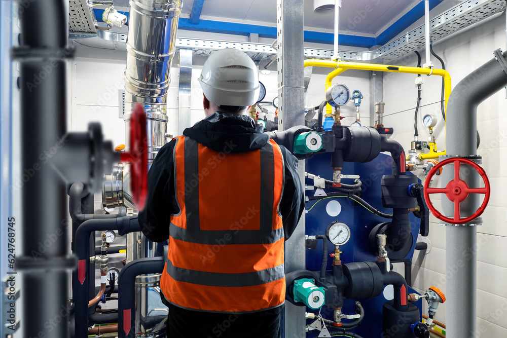 Engineer with back to camera. Man near boiler equipment. Worker in ...