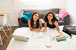 Cheerful smart teenagers doing school homework smiling