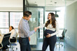 Businessman shaking hands with pregnant businesswoman in office