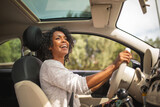 smiling young african american woman driving car