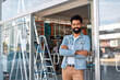 © Vergani Fotografia - Small business owner portrait. Happy brazilian black man in front of retail store with arms crossed and smiling
