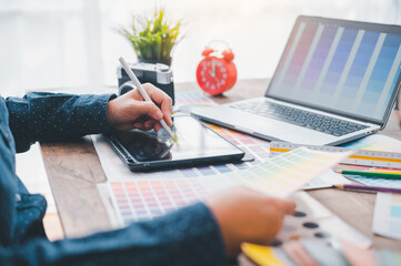 Fototapete - Graphic designer architects who work with laptops and color comparison tables for design work..