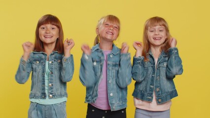 Wall Mural - Oh my God, Wow. Little child sisters looking surprised at camera with big eyes, shocked by sudden victory, game winning lottery goal achievement, good news. Three siblings children kids. Teenage girls