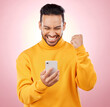 © Nadia L/peopleimages.com - Winner, man and phone for success, yes and celebration of online news, social media or gaming results. Excited, mobile games and person reading notification or website bonus on pink studio background