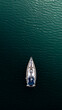 Top down aerial view of a sail boat sailing towards the light