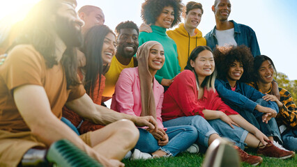 Wall Mural - Multicultural group of friends having fun outdoors - Young people celebrate together outside - Soft focus on Asian girl face