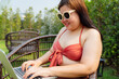 © Charlie's - Obese Woman Vacation Traveling working on laptop in hotel resort holiday remote online working digital Freelance work studying online e-learning 