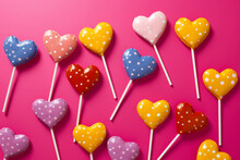 Group Of Heart Shaped Lollipops On Pink Background With Polka Dots. Generative AI.