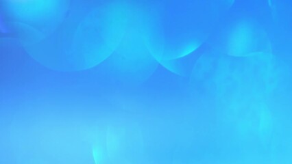 Wall Mural - Blue Bokeh Moving Background. Abstract motion of blurry lights. Amazing natural effect of defocused circles and light beams. Heavenly or oceanic dreaming of light leaks.