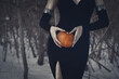 © junky_jess - Beautiful female body in black tight dress with a pumpkin in hands in the dark forest, selective focus.