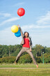 © darkbird - Young beautiful happy business woman with long hair jumping with air balloons outdoor