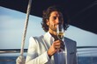 Leinwandbild Motiv Young rich prosperous confident businessman stylish fashionable man guy male in white trendy suite holding glass of champagne on luxury yacht vacation dating luxurious traveling wealth lifestyle