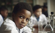 © ADDICTIVE STOCK - Generative AI image of portrait of confident black kid looking at camera while sitting with classmates in blurred classroom with lab equipment