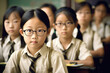 © ADDICTIVE STOCK - Generative AI image of Asian preteen kid in eyeglasses and uniform sitting at table in classroom against blurred background