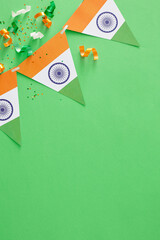 India Independence Day festive concept. Top view vertical composition of indian flag garlands, patriotic confetti on pastel green background with blank space for promo or text