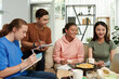 © DragonImages - Group of teens having snacks when studying at home