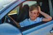© chaossart - Handsome successful smiling boy sitting in driver's seat of the car