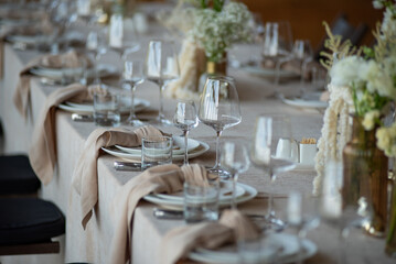 beautiful table setting with flowers and cutlery on wooden table at wedding or dinner. stylish tablewear decorations