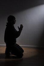 Homem De Joelhos Fazendo Oração Sozinho Recebendo Luz 