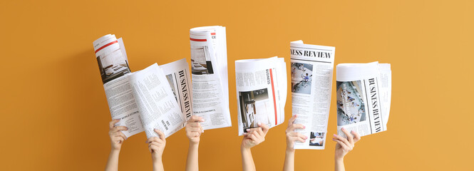 Poster - Female hands with newspapers on orange background