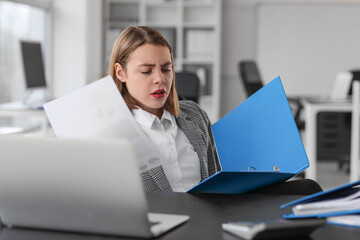 Canvas Print - Upset female accountant working with documents at table in office