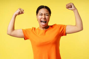 Portrait of beautiful smiling African American woman wearing orange t shirt rejoicing