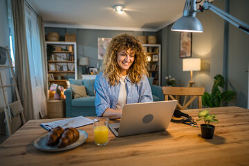 Wall Mural - one woman adult caucasian work on her laptop at home happy smile