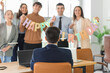 © Pixel-Shot - Young man with his colleagues at birthday party in office, back view