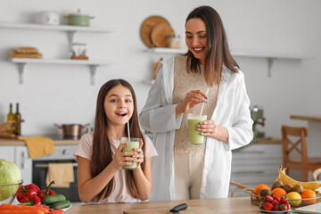 Sticker - Little girl with her pregnant mother drinking green smoothie in kitchen