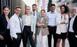 © CarlosBarquero - Team portrait multi-ethnic professionals smiling posing with confidence. Young and mature colleagues looking at camera cheerful expression. Group of office workers outside a startup business company.