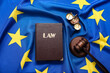 Law book, scales of justice and judge's gavel on European Union flag