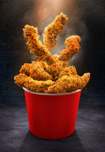 Fried Chicken Crispy Tenders Breast Crunchy Pieces Fall Into The Bucket - A Large Red Box	With A Black Table And Wall - Poster Design
