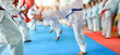 People in martial arts training exercising taekwondo with blur motion