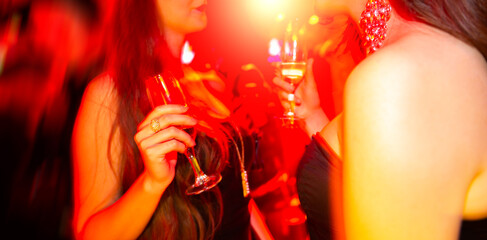 Two young women in club with glass of wine