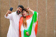 © PRASANNAPIX - Indian couple in traditional wear and taking selfie in smartphone.