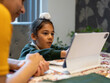 Mother homeschooling son (6-7) using digital tablet