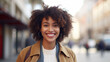 Happy young african american woman smiling in the city street , closeup Portrait of a happy young adult African girl standing on a European city outdoor