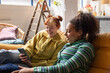 © ReeldealHD images - Two young adult friends looking at a smartphone together in a shared loft apartment