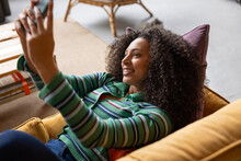 Young Adult Woman Taking A Selfie Lying On Sofa 