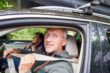 Wall Mural - Elderly man wearing seat belt while traveling in car