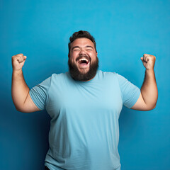 Excited fat man celebrating success. Happy plus size bearded man on blue background