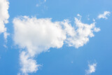 Fototapeta Niebo - White fluffy clouds on a bright blue sky
