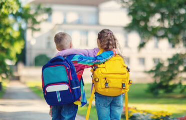 Boy and girl standing and hugging in the park near the school.