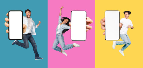 Positive young multiracial people jumping from joy and show phone