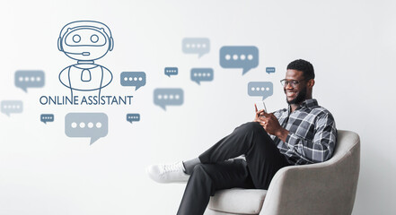 happy young black guy sitting on chair, using smartphone