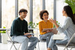 © Prostock-studio - Happy diverse college students working together on study project in university classroom, sitting on chairs in circle